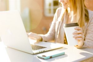 woman in front of laptop holding a cup | Mortgage process