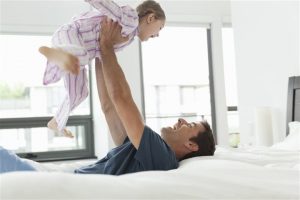 father and daughter playing in the bedroom