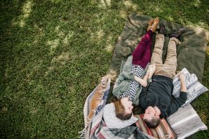 couple talking and lying in the grass