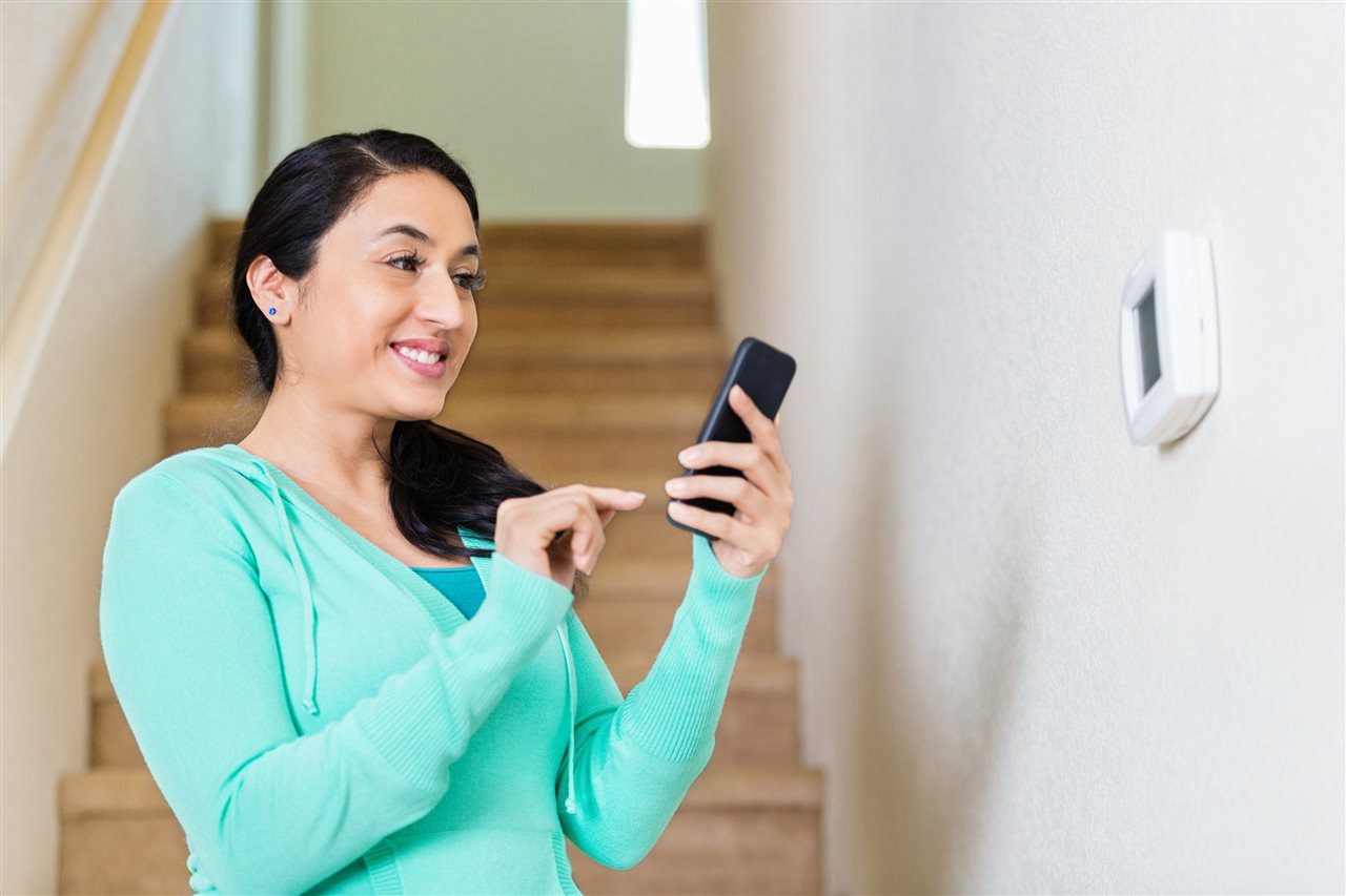 a woman smiling holding her phone | Chattanooga Home Inspector | Home Security Chattanooga