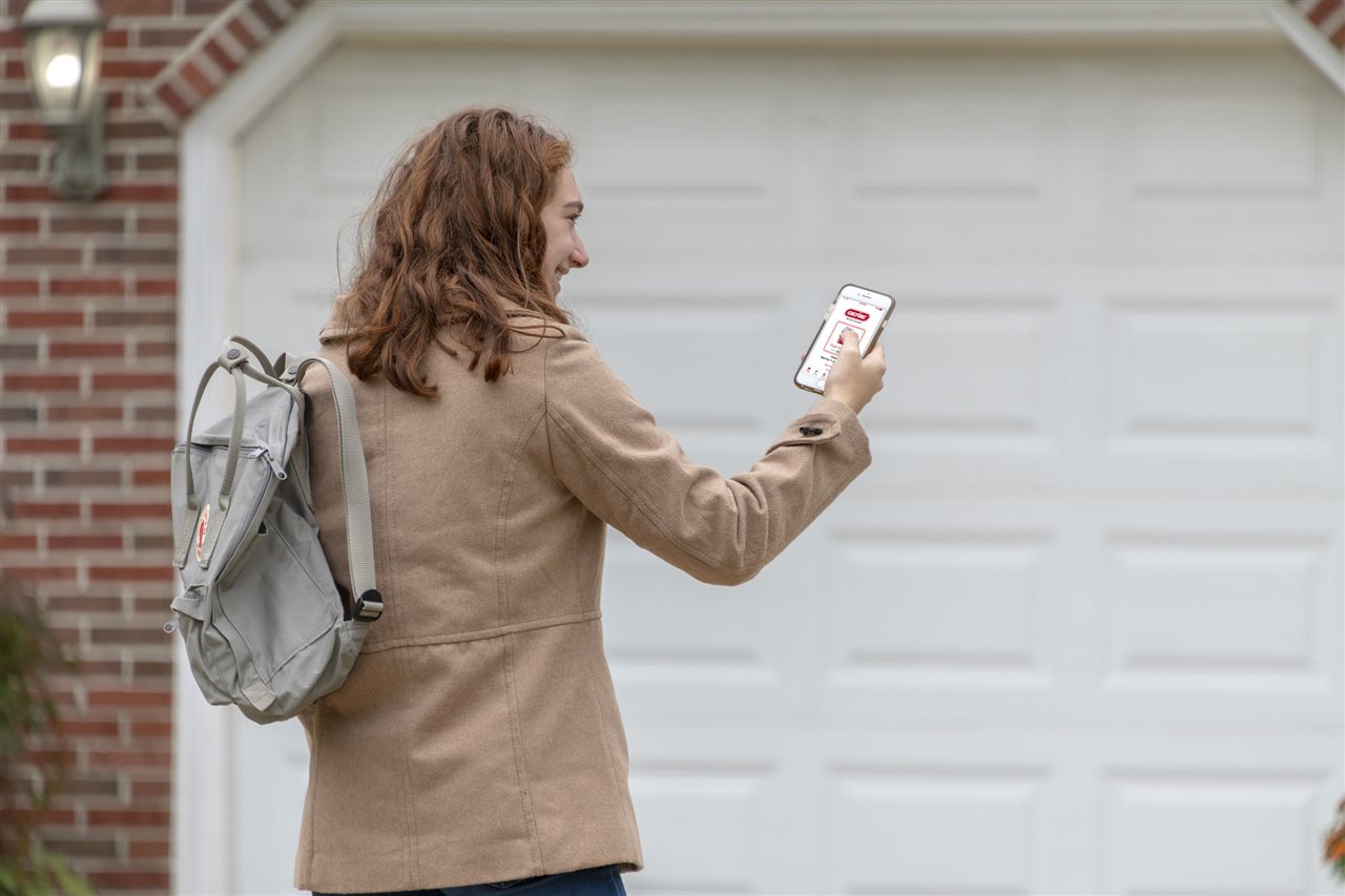 a woman looking at her phone outside the garage | Chattanooga Home Inspector | Connectivity Chattanooga
