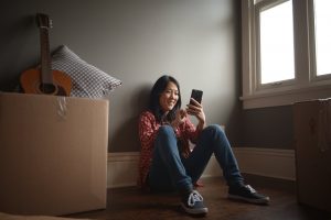 a girl sitting looking at her phone smiling | Chattanooga Home Inspector | moving made easy Chattanooga