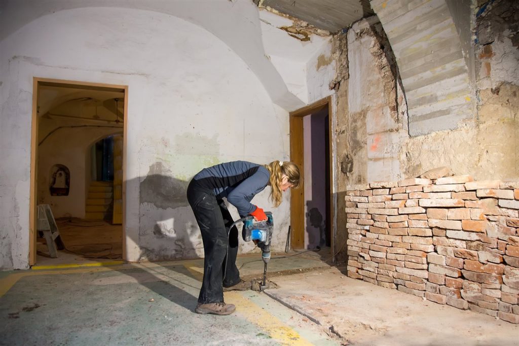  woman drilling the basement floor | Chattanooga Home Inspector | Bathroom in the basement Chattanooga
