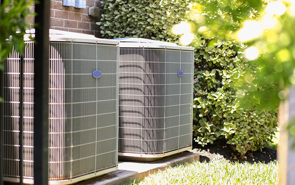 Picture of two HVAC units in the summer heat.